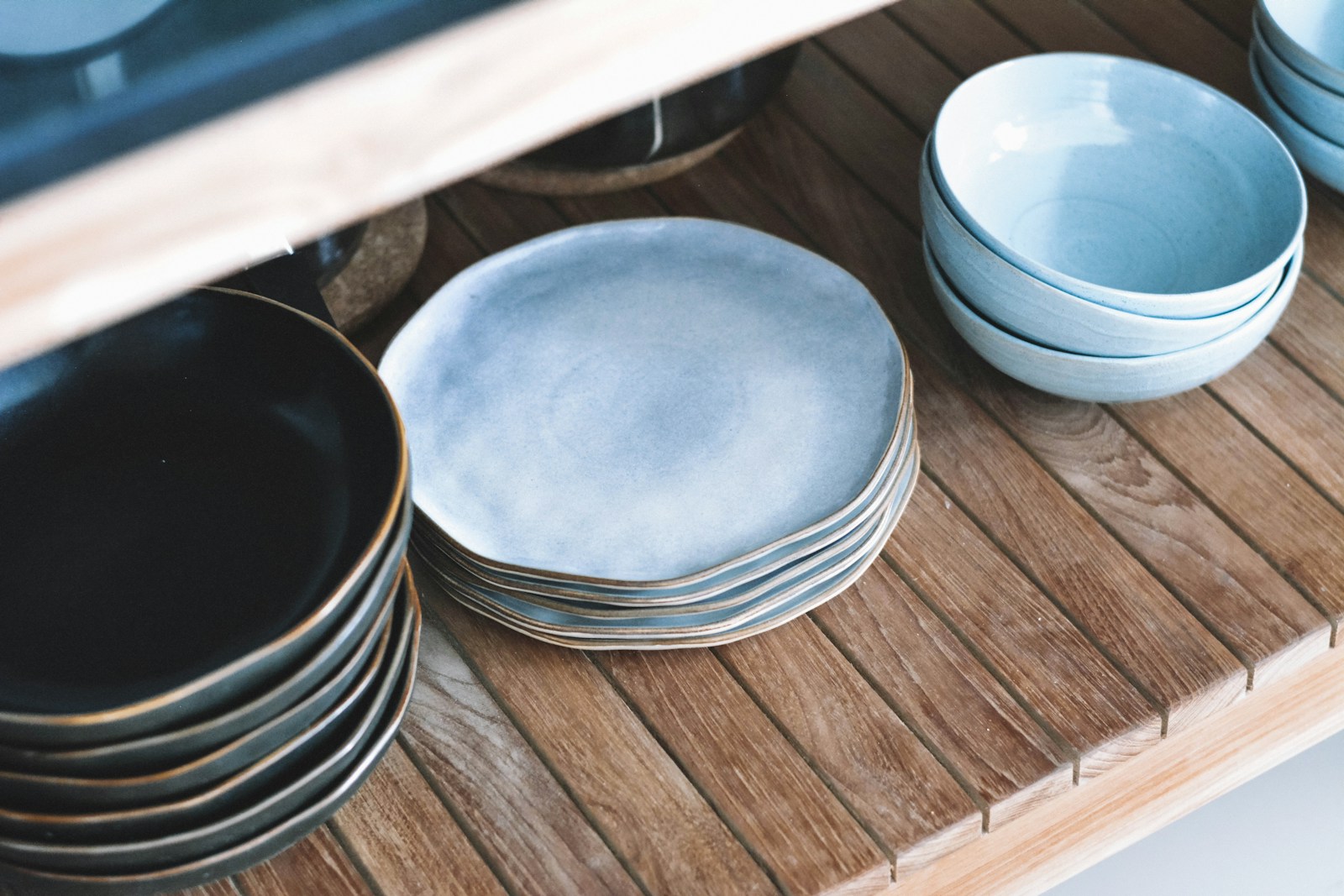 Blue ceramic plates and bowls on wooden shelves